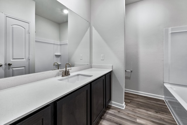 full bath featuring baseboards, wood finished floors, and vanity