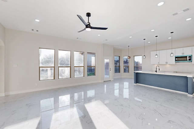 unfurnished living room with marble finish floor, visible vents, and baseboards