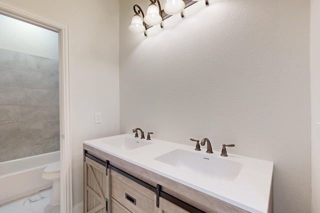 full bath featuring marble finish floor, double vanity, a sink, and toilet