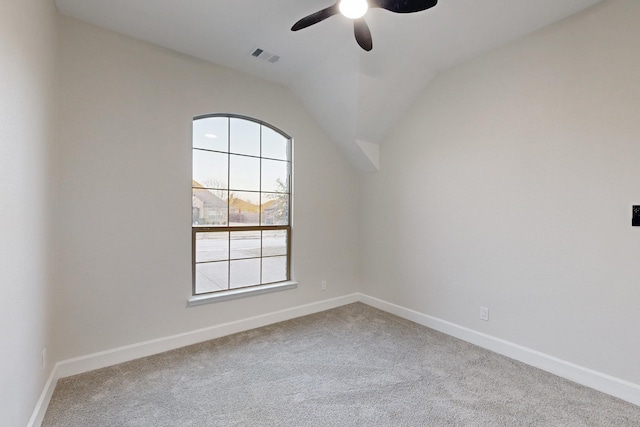 carpeted spare room featuring lofted ceiling, baseboards, visible vents, and ceiling fan