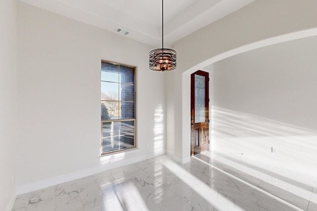 interior space with marble finish floor, visible vents, arched walkways, and baseboards