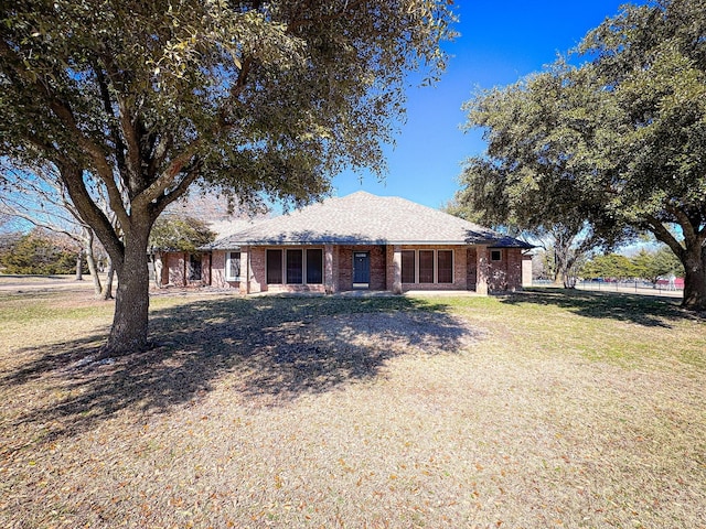 ranch-style home with brick siding and a front lawn