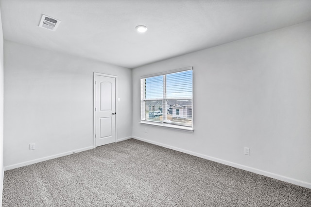 carpeted empty room featuring visible vents and baseboards