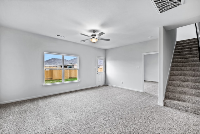 unfurnished room with carpet floors, baseboards, stairs, and visible vents