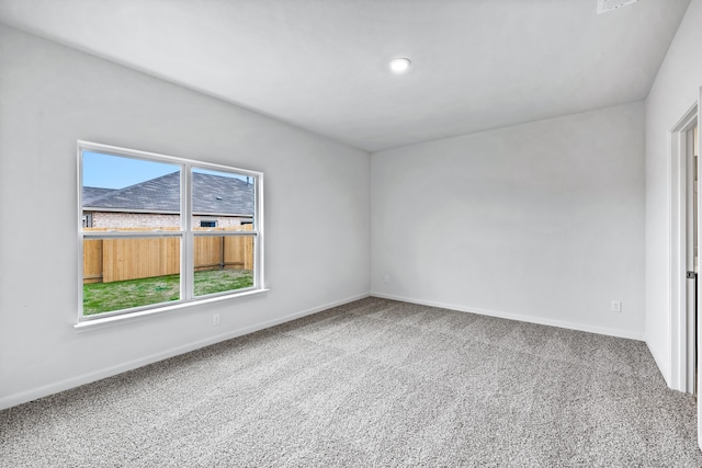 spare room featuring carpet and baseboards