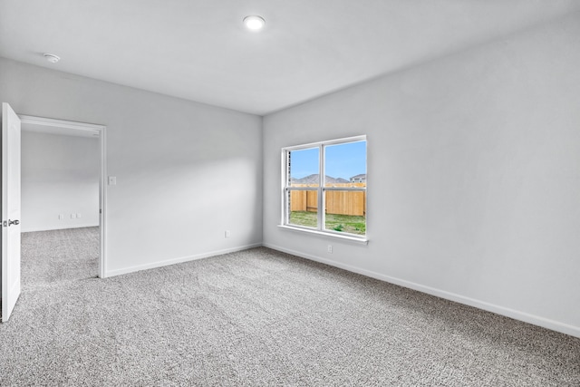 carpeted spare room with baseboards