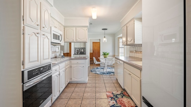 kitchen with white appliances, white cabinets, light countertops, pendant lighting, and backsplash