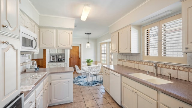 kitchen featuring pendant lighting, white appliances, a sink, backsplash, and crown molding