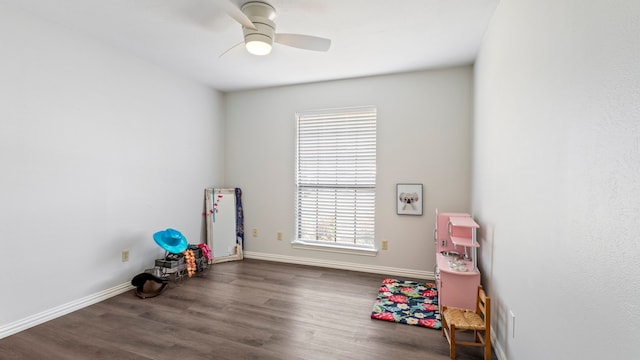 recreation room featuring dark wood finished floors, baseboards, and ceiling fan