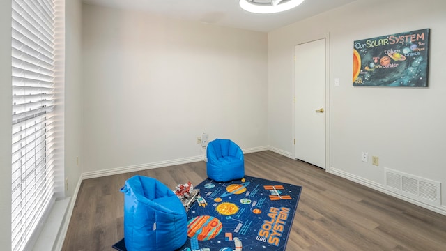 playroom featuring wood finished floors, visible vents, and baseboards