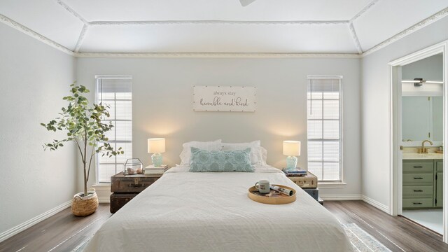 bedroom featuring wood finished floors, multiple windows, and vaulted ceiling