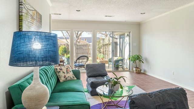 living area with a textured ceiling, visible vents, baseboards, tile patterned floors, and crown molding