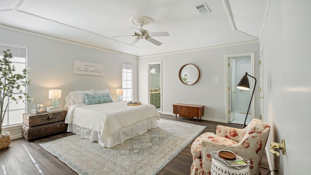 bedroom with baseboards, visible vents, a ceiling fan, connected bathroom, and dark wood-type flooring