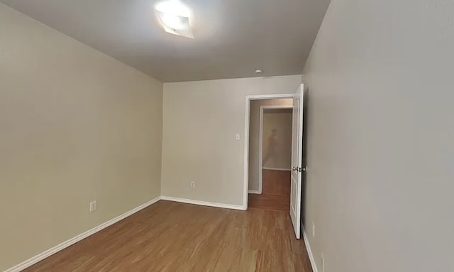 spare room featuring light wood finished floors and baseboards