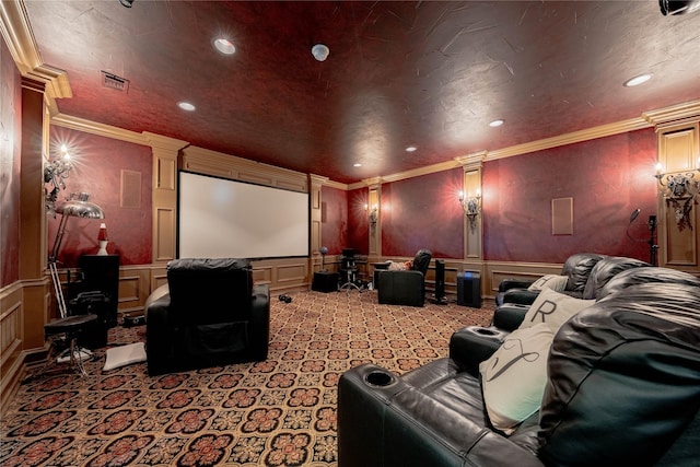 home theater room featuring decorative columns, visible vents, a decorative wall, and ornamental molding