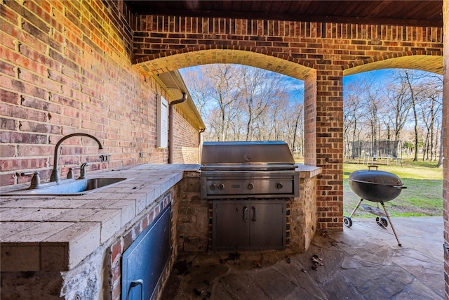 view of patio featuring a sink, area for grilling, and a grill