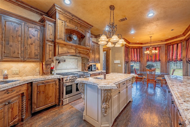 kitchen featuring range with two ovens, brown cabinets, visible vents, hanging light fixtures, and a chandelier