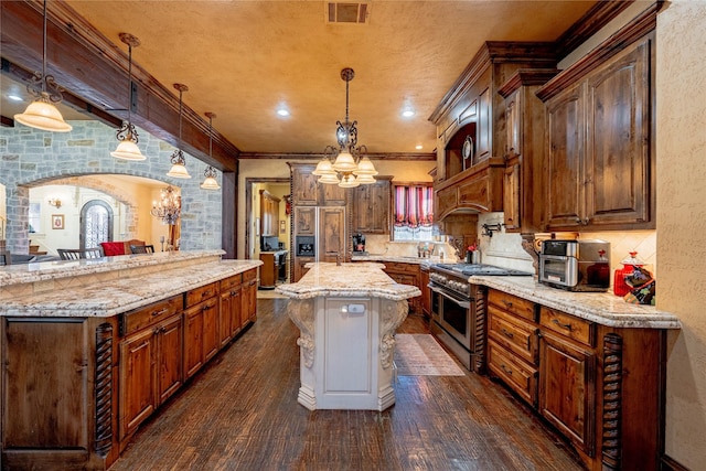 kitchen with arched walkways, visible vents, high quality appliances, a center island, and pendant lighting