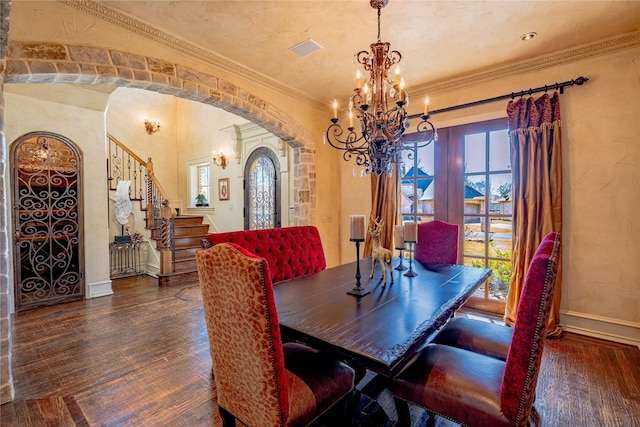 dining room with arched walkways, crown molding, dark wood finished floors, baseboards, and stairs