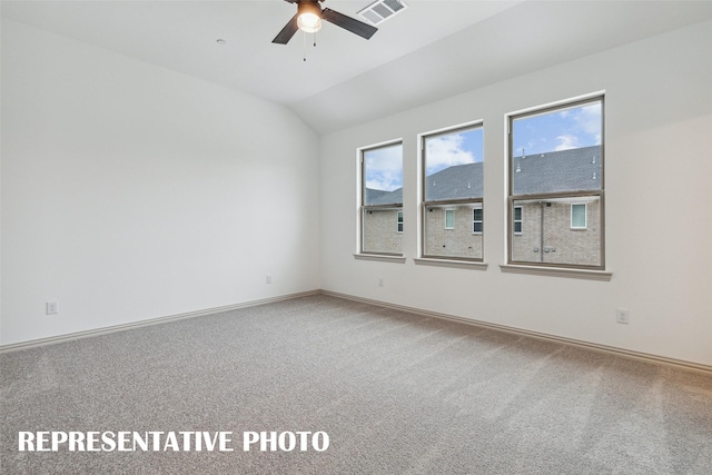 spare room featuring lofted ceiling, ceiling fan, carpet flooring, visible vents, and baseboards