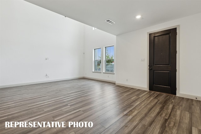 spare room with recessed lighting, visible vents, baseboards, and wood finished floors