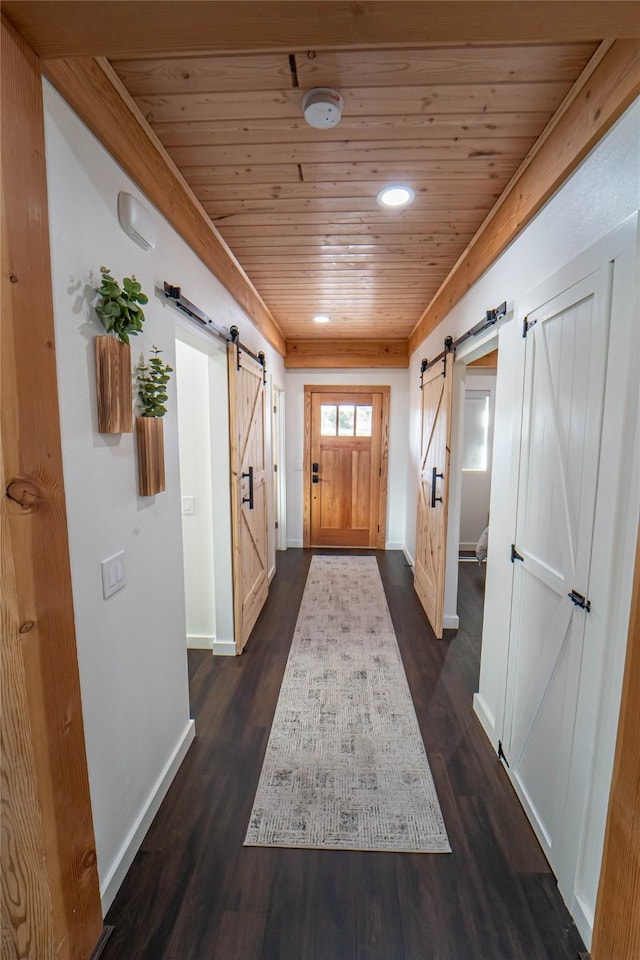 doorway with dark wood-type flooring, wood ceiling, and a barn door