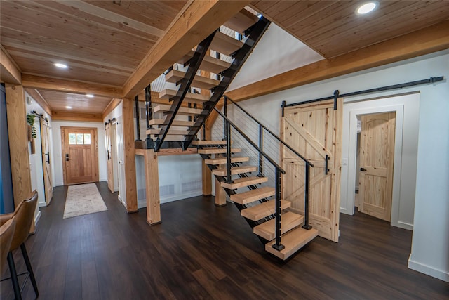 entrance foyer with a barn door, baseboards, dark wood finished floors, and wooden ceiling