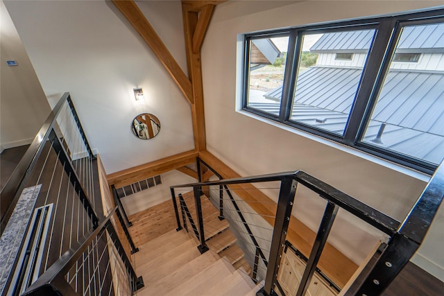 staircase featuring wood finished floors and baseboards