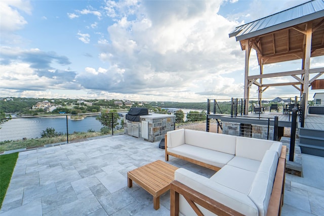 view of patio with outdoor lounge area, an outdoor kitchen, and a water view