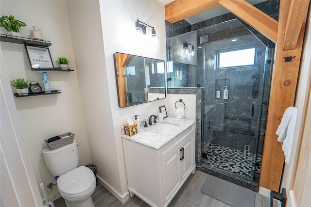 full bath with a marble finish shower, toilet, vanity, wood finished floors, and baseboards