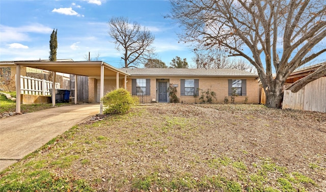 ranch-style home with a garage, an attached carport, concrete driveway, and brick siding