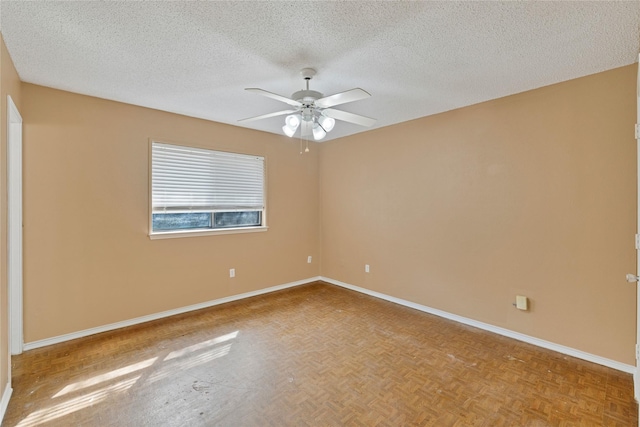 spare room with ceiling fan, a textured ceiling, and baseboards