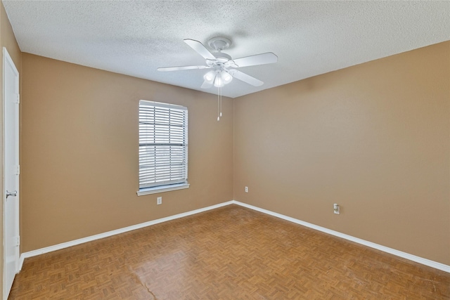 empty room with a ceiling fan, a textured ceiling, and baseboards