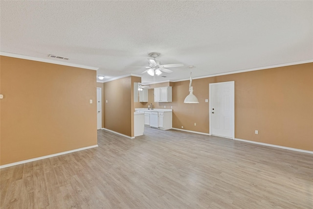 unfurnished living room featuring a textured ceiling, light wood-type flooring, visible vents, and crown molding