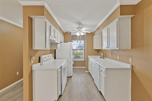 kitchen featuring white appliances, light countertops, light wood-type flooring, white cabinetry, and a sink