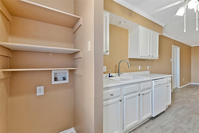 kitchen featuring dishwasher, light countertops, crown molding, white cabinetry, and a sink