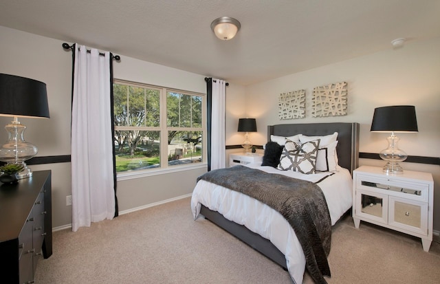 bedroom with light carpet and baseboards