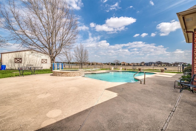 view of pool with an outbuilding, a patio area, fence, and a pool with connected hot tub