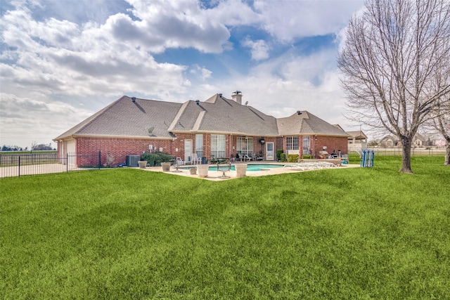 back of property featuring central air condition unit, brick siding, a patio, and a lawn