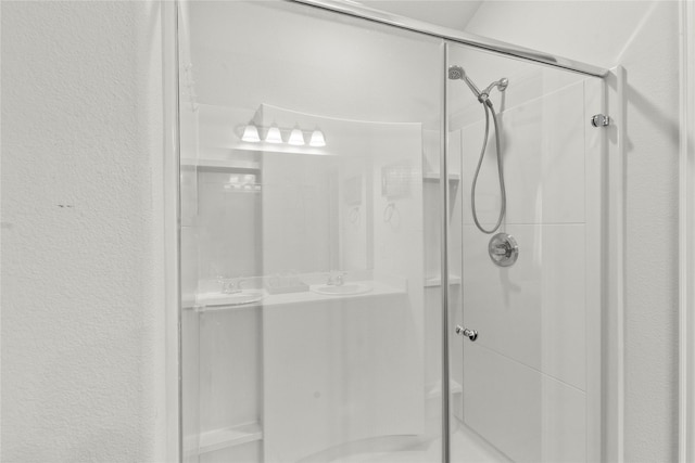 bathroom featuring a stall shower and a sink