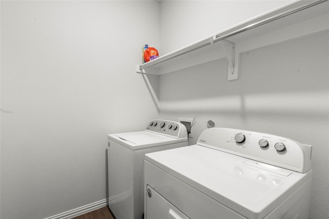 laundry area with washer and dryer, laundry area, dark wood-style flooring, and baseboards