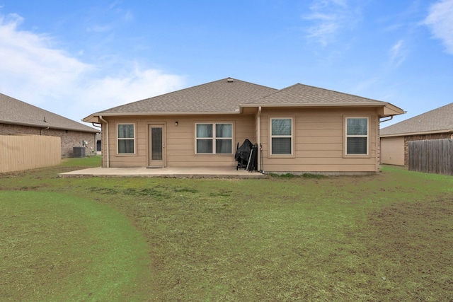 back of house with a yard, a fenced backyard, a patio, and roof with shingles