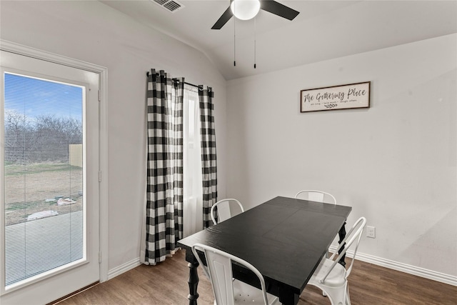 dining space with lofted ceiling, wood finished floors, a ceiling fan, and baseboards