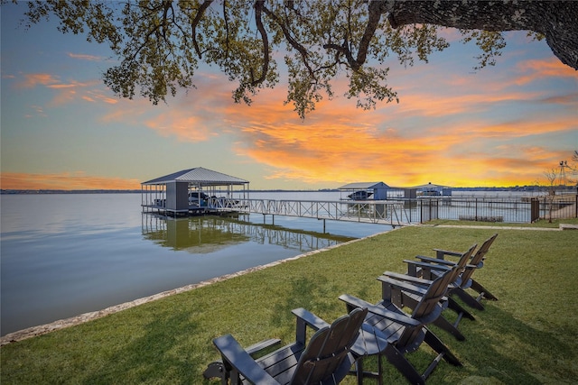 view of dock featuring a water view and a yard