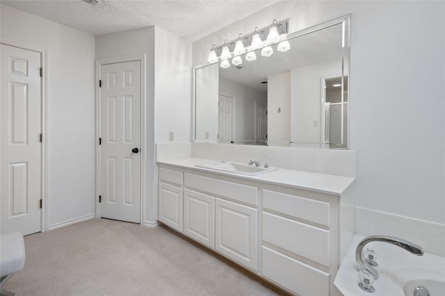 bathroom with a textured ceiling, carpet floors, vanity, and a tub