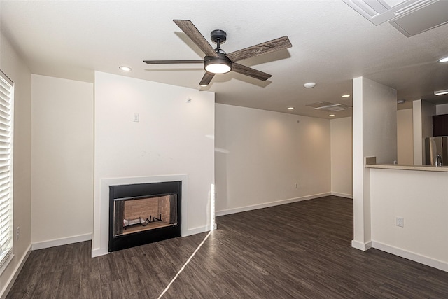 unfurnished living room with dark wood-style flooring, a fireplace, and baseboards