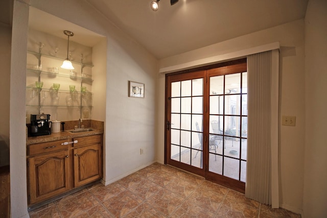 doorway featuring baseboards and a sink