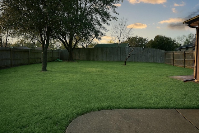 yard at dusk with a fenced backyard