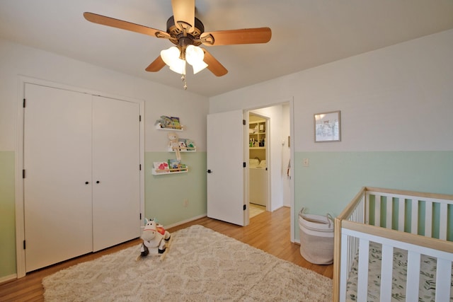 bedroom with a closet, baseboards, light wood-type flooring, and ceiling fan