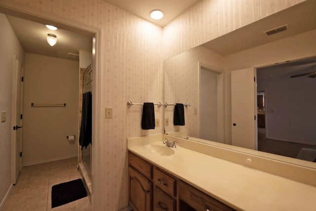 full bathroom featuring a shower stall, vanity, visible vents, and wallpapered walls